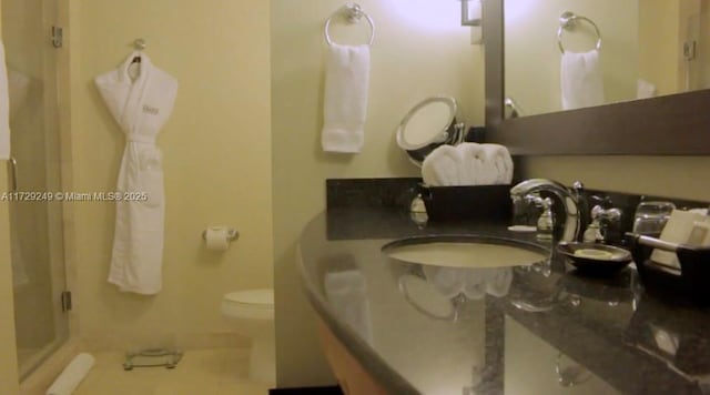 bathroom with toilet, tile patterned floors, a shower with door, and sink