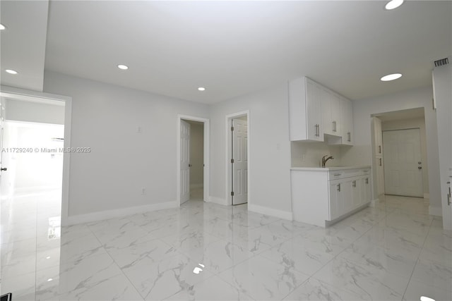 kitchen featuring white cabinetry and sink