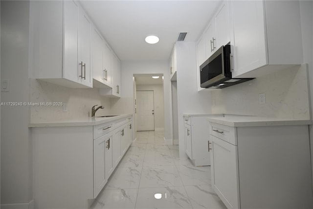 kitchen featuring sink and white cabinets