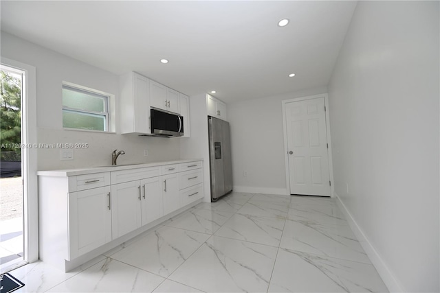 kitchen featuring sink, stainless steel appliances, and white cabinetry