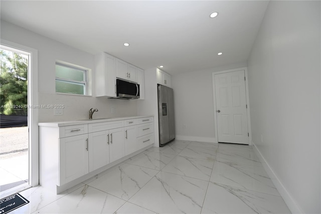 kitchen featuring sink, white cabinets, and stainless steel appliances