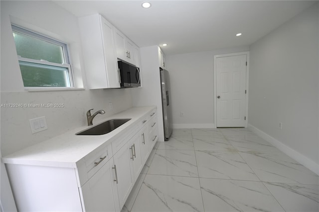 kitchen featuring stainless steel appliances, white cabinetry, and sink