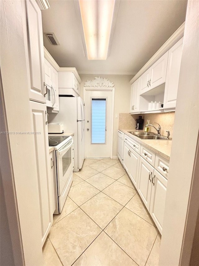 kitchen with white cabinets, sink, and white appliances