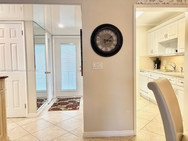 interior space featuring sink, light tile patterned floors, and crown molding