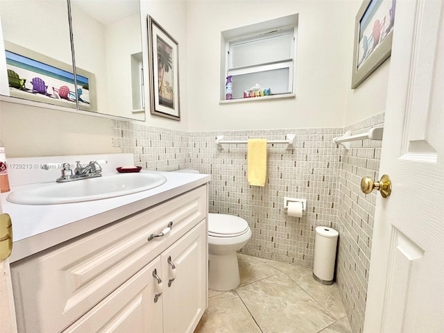 bathroom with tile patterned floors, tile walls, toilet, and vanity