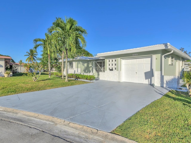 ranch-style home with a garage and a front lawn