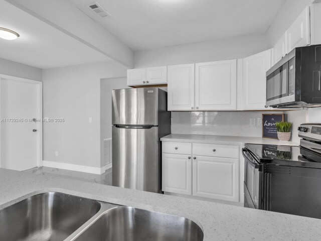 kitchen featuring backsplash, sink, white cabinetry, and appliances with stainless steel finishes