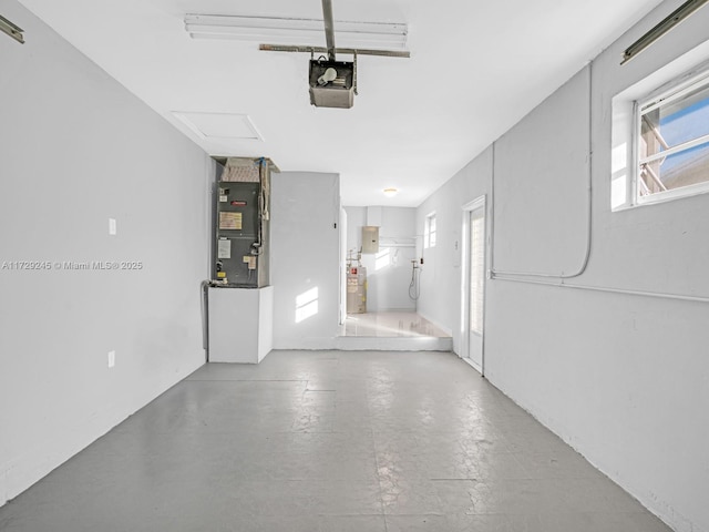 garage featuring heating unit, water heater, and a garage door opener