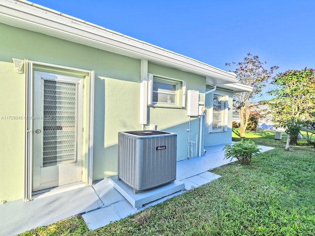 view of side of home featuring a yard and central air condition unit