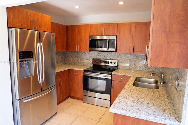 kitchen with tasteful backsplash, sink, light tile patterned floors, light stone counters, and stainless steel appliances