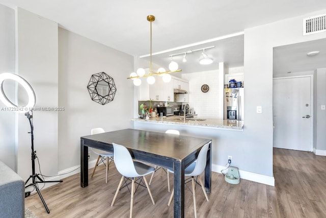 dining space with sink and light hardwood / wood-style flooring