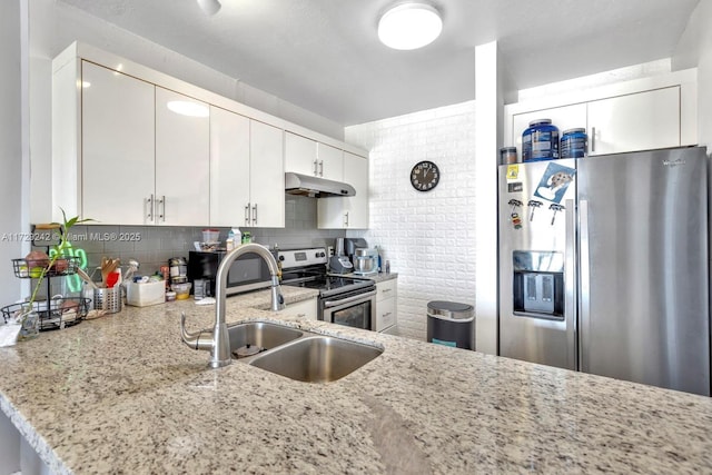 kitchen with sink, white cabinets, stainless steel appliances, light stone countertops, and backsplash