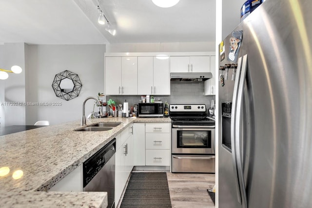 kitchen with white cabinetry, sink, backsplash, stainless steel appliances, and light stone countertops