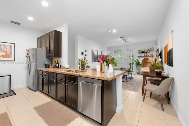 kitchen with light tile patterned floors, appliances with stainless steel finishes, sink, and dark brown cabinetry