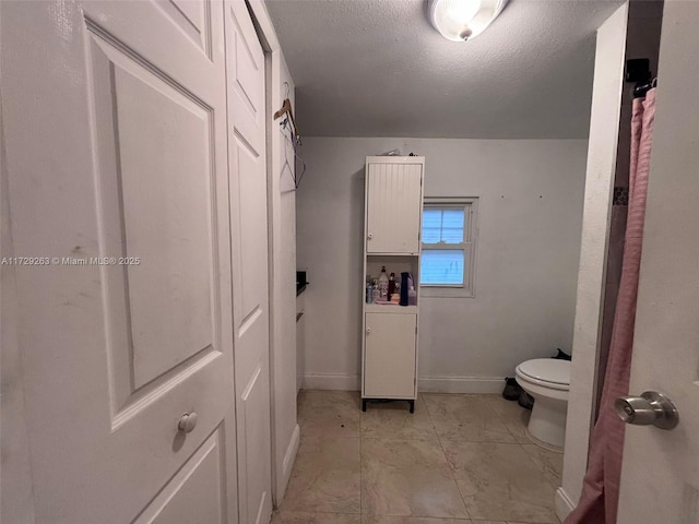 bathroom featuring a textured ceiling and toilet