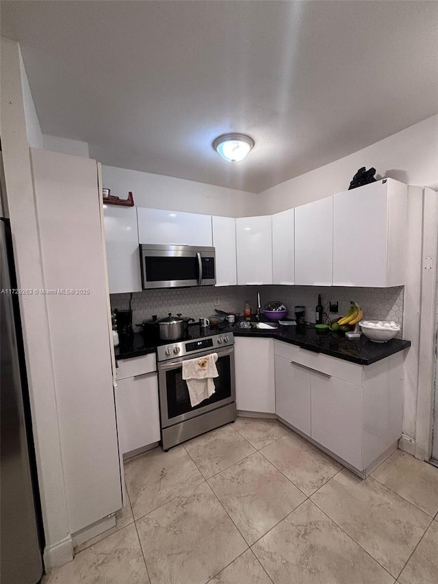 kitchen with backsplash, white cabinetry, and stainless steel appliances