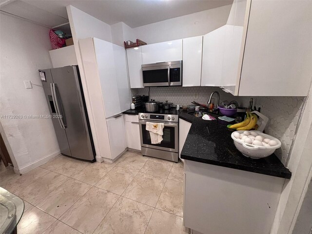 kitchen featuring decorative backsplash, sink, white cabinets, and stainless steel appliances