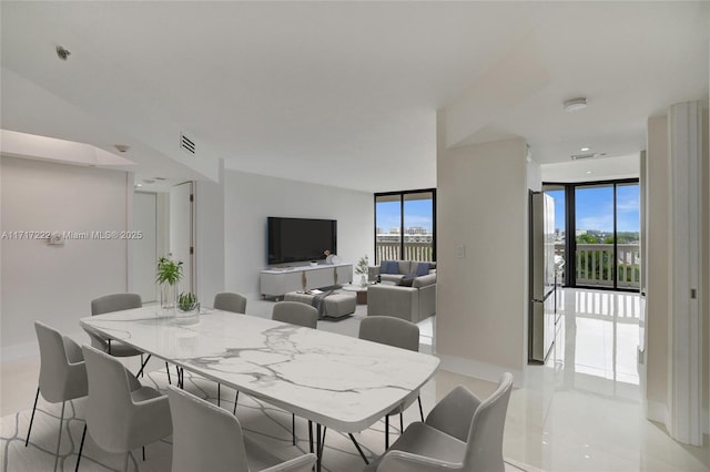 tiled dining space featuring a wall of windows and plenty of natural light