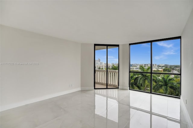 unfurnished room featuring a wall of windows