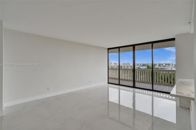 unfurnished room with a wall of windows