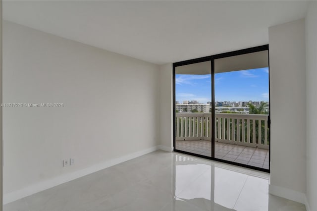 tiled spare room featuring floor to ceiling windows