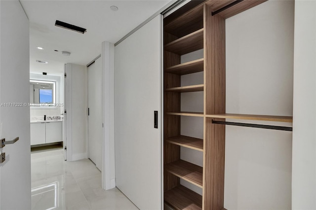 walk in closet with light tile patterned floors