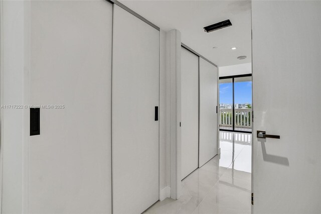 hall featuring light tile patterned floors and a wall of windows