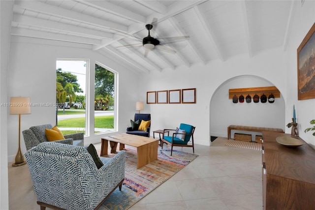 tiled living room with ceiling fan and vaulted ceiling with beams