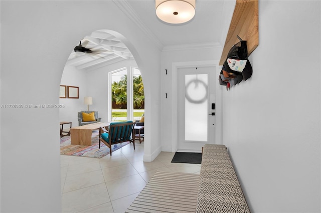 tiled entryway featuring ceiling fan and crown molding