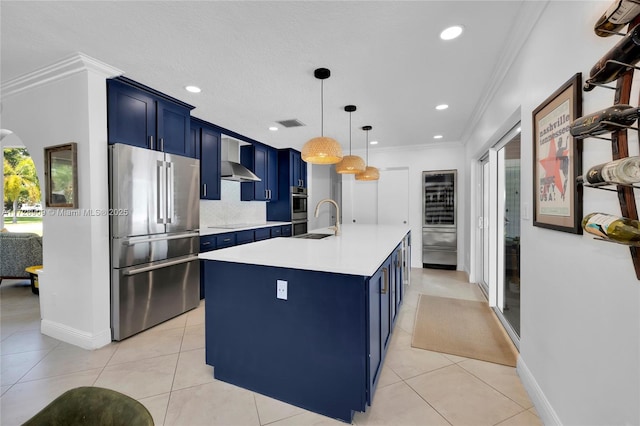 kitchen featuring hanging light fixtures, a kitchen island with sink, appliances with stainless steel finishes, and blue cabinets