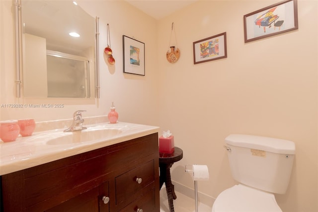 bathroom with toilet, vanity, and an enclosed shower