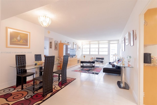 dining area featuring tile patterned floors and an inviting chandelier