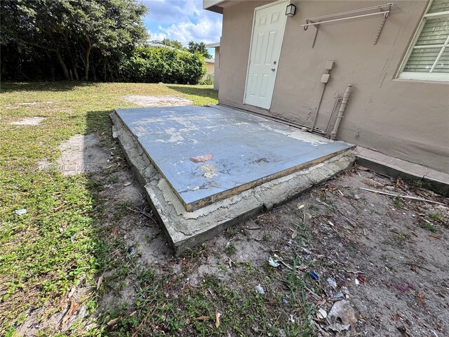 entry to storm shelter featuring a lawn