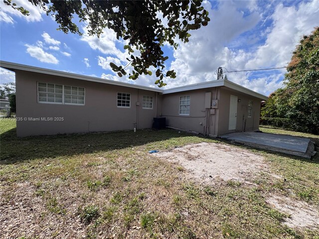 back of property with a patio area and a yard