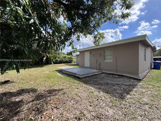 rear view of house featuring a yard and a patio