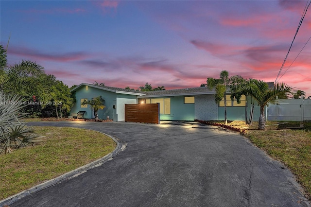 single story home featuring a lawn