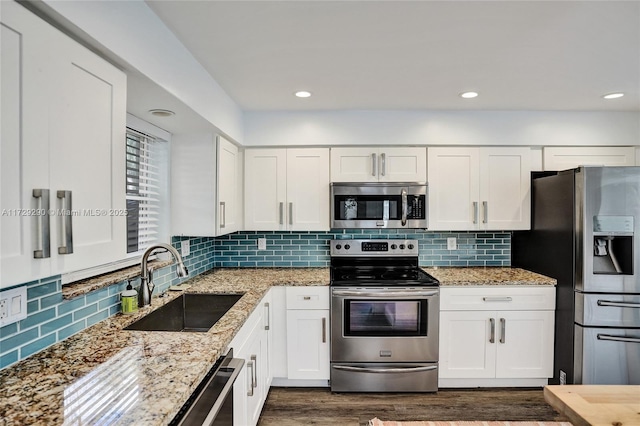 kitchen featuring light stone countertops, sink, white cabinetry, and stainless steel appliances