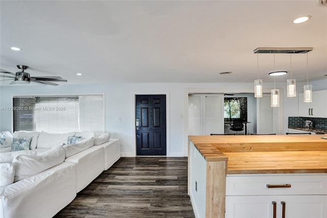 kitchen featuring tasteful backsplash, wooden counters, white cabinetry, and pendant lighting