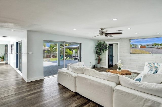 living room with dark hardwood / wood-style flooring and wooden walls