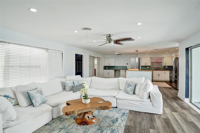 living room featuring ceiling fan and light hardwood / wood-style floors