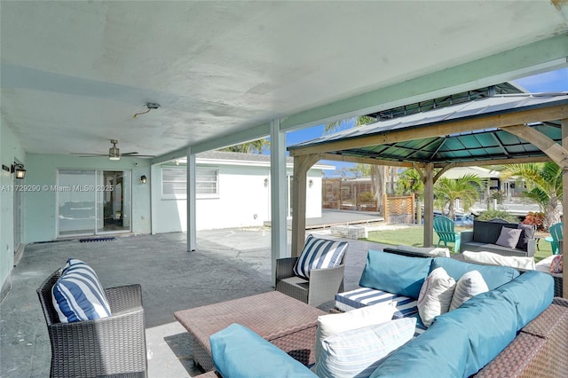 view of patio featuring ceiling fan, a gazebo, and an outdoor living space