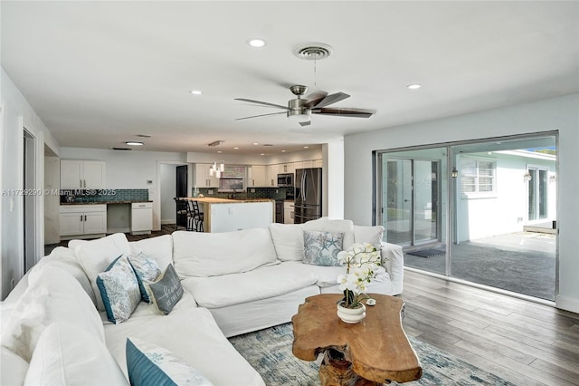 living room featuring ceiling fan and hardwood / wood-style flooring