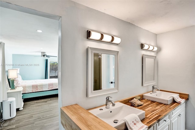 bathroom featuring ceiling fan, wood-type flooring, and vanity