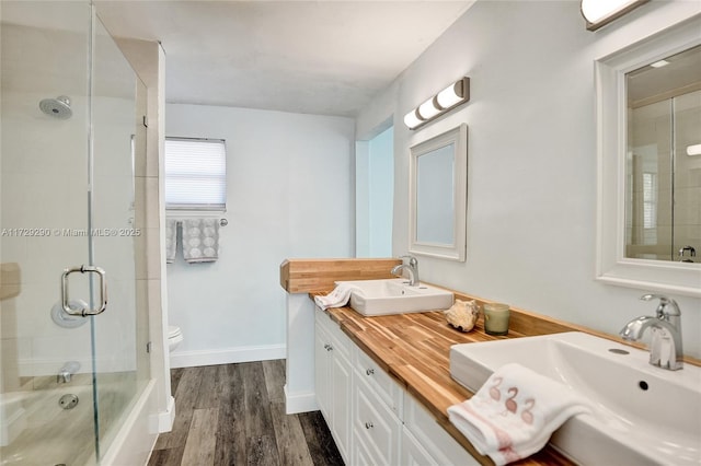 full bathroom featuring wood-type flooring, toilet, vanity, and shower / bath combination with glass door