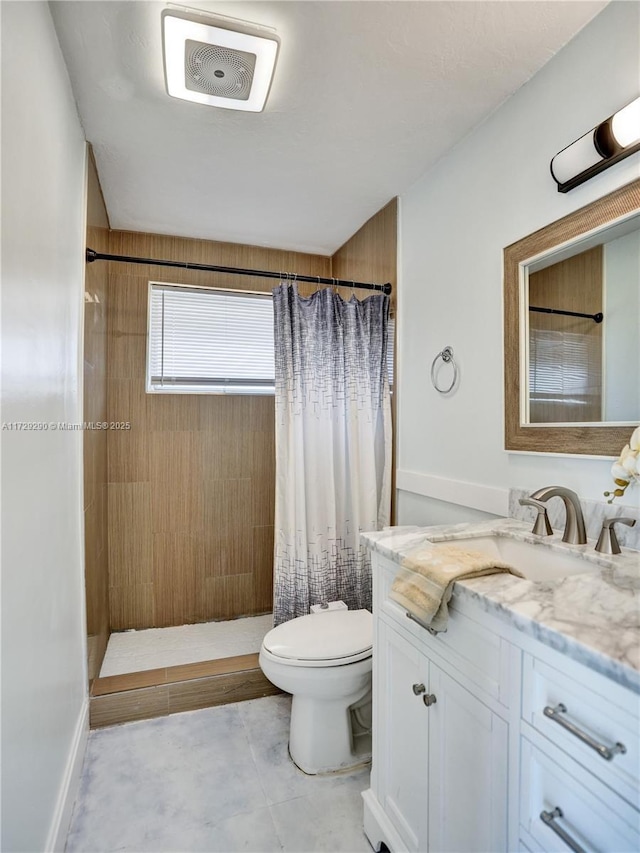 bathroom featuring toilet, vanity, and curtained shower