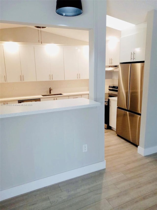 kitchen featuring sink, stainless steel appliances, light hardwood / wood-style floors, and white cabinets