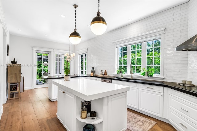 kitchen featuring white cabinetry, a kitchen island, sink, and plenty of natural light