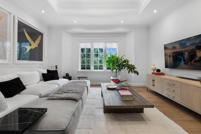 living room featuring hardwood / wood-style floors, a tray ceiling, and ornamental molding