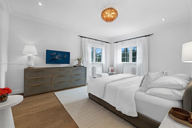 bedroom with ornamental molding and wood-type flooring