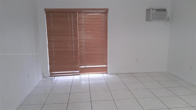 empty room featuring light tile patterned floors and a wall mounted AC